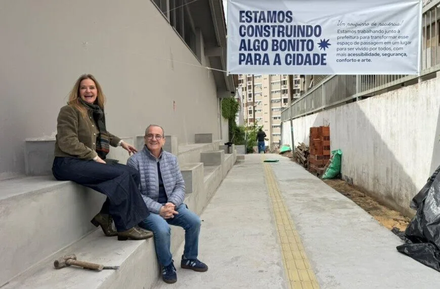 Tatiana Druck e Raul Hermann Coppetti sentados na arquibancada do Caminito em obras, sob a faixa Estamos construindo algo bonito para a cidade