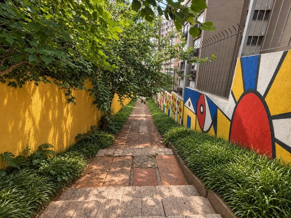 Projeto do Caminito del Sabor: caminho entre muros pintados com formas geométricas em azul, vermelho e amarelo